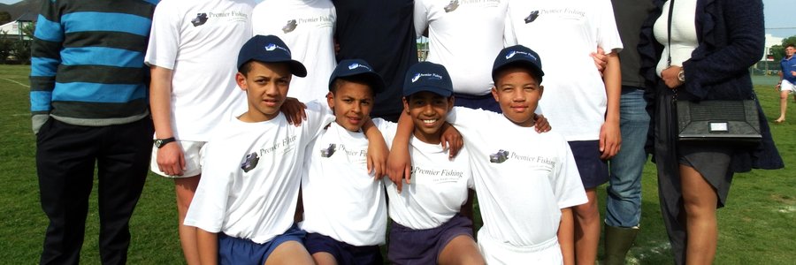 Laerskool  Gansbaai  se  trotse  o/13A-rugbyspan  met  hulle pette en T-hemde van Premier Fishing, met Tatenda Bundo (links), Jonathan Doyle (middel), Rushaan Isaacs (regs) en JP Coetzer langs haar